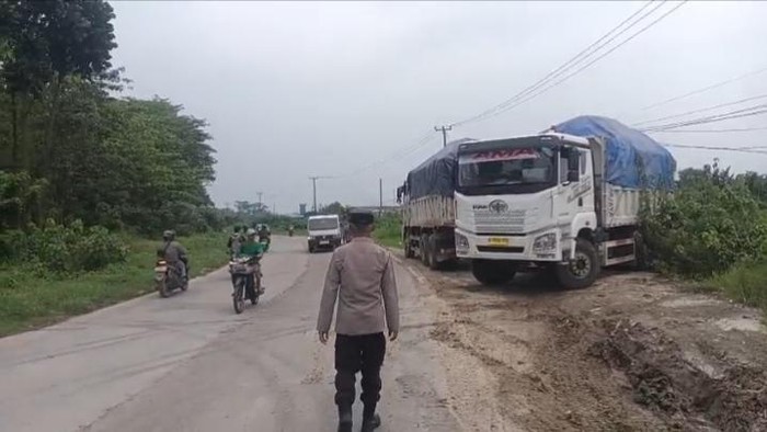 Petugas Polsek Jawilan, Polres Serang, menindak dump truk bermuatan pasir dan tanah urugan yang melanggar kebijakan pembatasan truk tambang, Senin (11/5/2026).