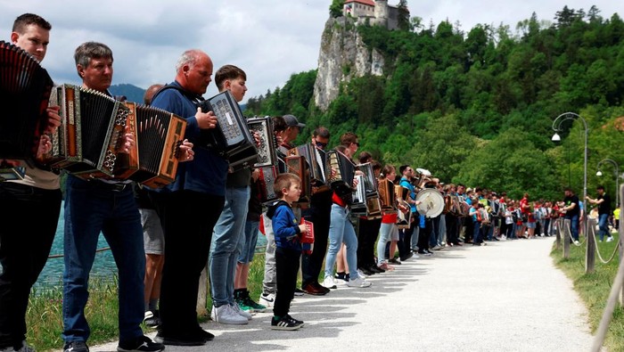 Ratusan pemain akordeon berkumpul di tepi Danau Bled untuk mengikuti festival tahunan akordeon yang menjadi salah satu tradisi budaya populer di Slovenia. Acara tersebut kembali menarik perhatian wisatawan dan warga lokal di Bled, Slovenia, Minggu (10/5/2026). Foto : REUTERS /Borut Zivulovic