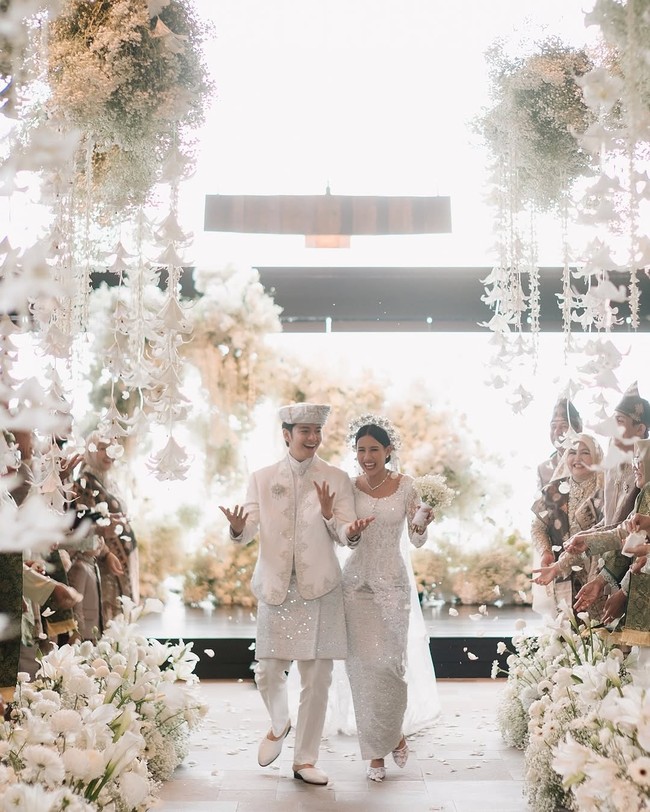 Pernikahan Shenina Cinnamon dan Angga Yunanda menghadirkan dekorasi serba putih yang sangat dreamy dan ethereal. Dekorasi mereka juga memanfaatkan layering tekstur bunga putih yang berbeda-beda seperti Lily, Baby’s breath, Anggrek, Hydrangea dan Krisan, agar tidak monoton. Foto: Instagram