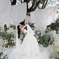 Tema all-white wedding kini tak lagi terlihat polos atau monoton. Dengan permainan tekstur bunga, layering dekorasi, hingga pencahayaan yang tepat, dekorasi putih bisa terlihat sangat mewah dan dreamy, seperti pernikahan pasangan aktris-aktor Thailand, Davika Hoorne dan Chantavit Dhanasevi. Foto: Instagram