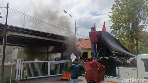 Mahasiswa membakar ban di depan kantor Kejati NTT, Selasa (12/5/2026).