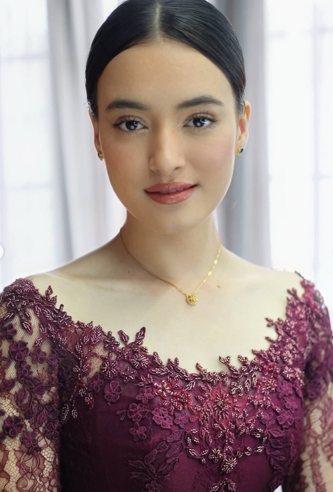 Potongan leher semi-sabrina membuat area bahu dan leher Mawar Eva terlihat jenjang. Rambutnya ditata sleek bun dengan belahan tengah yang simpel namun berkelas. Foto: Instagram/@ryanogilvy