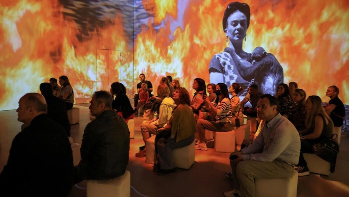 A visitor looks at costumes inspired by the artist, at the exhibition 