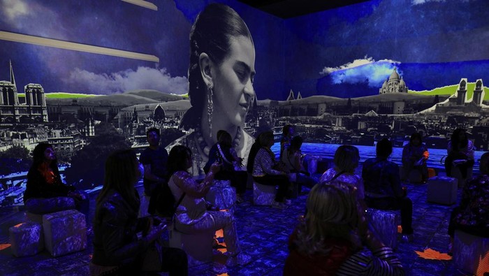 A visitor looks at costumes inspired by the artist, at the exhibition 