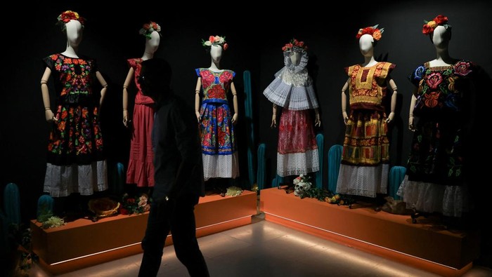 A visitor looks at costumes inspired by the artist, at the exhibition 