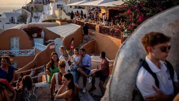 FILE PHOTO: Tourists wait to view Santorini’s famed sunset, on Santorini, Greece, July 25, 2024. REUTERS/Alkis Konstantinidis/File Photo