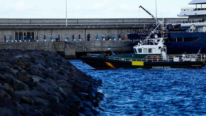 Tourists wait at the dock after disembarking from the cruise ship MV Hondius, affected by a hantavirus outbreak, at the port of Granadilla de Abona, Tenerife, Spain May 11, 2026. REUTERS/Borja Suarez