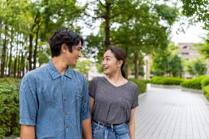 Japanese married couple standing outside, looking eye to eye