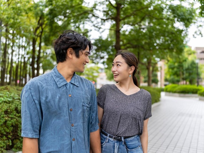 Japanese married couple standing outside, looking eye to eye