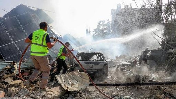 Para petugas tanggap darurat berkumpul di lokasi kejadian setelah pemboman Israel yang menghantam salah satu fasilitas mereka di desa Arnoun di Lebanon selatan pada 12 Mei 2026. (AFP)