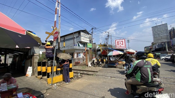 Petugas sedang memperbaiki palang kereta api di Sukabumi.