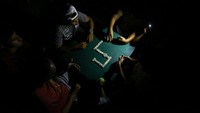 Warga berkumpul dengan penerangan terbatas saat pemadaman listrik berlangsung di Valencia. Krisis energi yang berkepanjangan memengaruhi kehidupan sehari-hari warga, mulai dari komunikasi, penyimpanan makanan, hingga aktivitas sosial masyarakat. REUTERS/Juan Carlos Hernandez