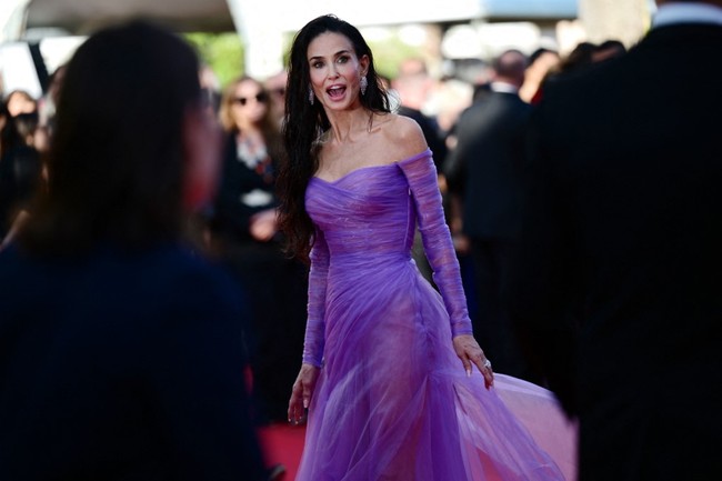 Bagian rok gaun membalut tubuh Demi Moore dengan belahan paha tinggi serta material semi-transparan. Penampilannya ini seolah melawan aturan kontroversial Cannes terkait larangan naked dressing. Namun Demi Moore mengakalinya dengan cara yang elegan. Foto: AFP/VALERY HACHE
