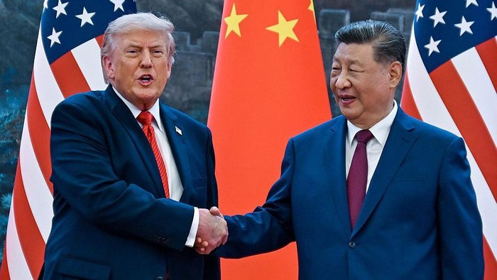 Presiden AS, Donald Trump (kiri), berjabat tangan dengan Presiden China, Xi Jinping, di Beijing, Kamis (14/05) (AFP via Getty Images)