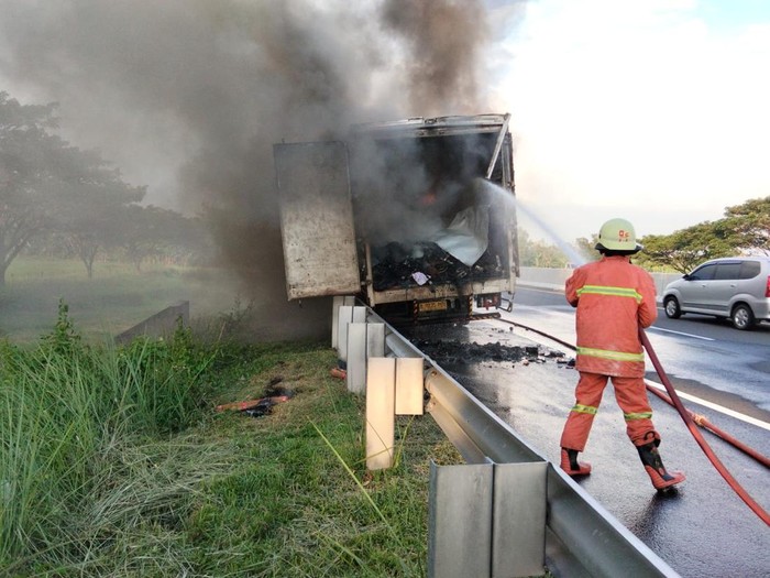 Momen pemadam kebakaran menjinakkan api yang membakar 1 unit mobil boks ekspedisi di Tol Sragen, Kamis (14/5/2026).