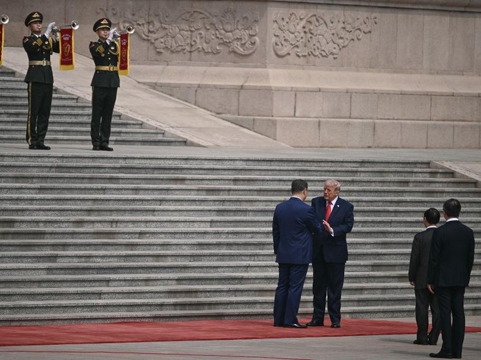 Momen Xi Jinping menyambut Trump dengan jabat tangan dalam seremoni penyambutan di Aula Besar Rakyat di Beijing pada Kamis (14/5) pagi (AFP/BRENDAN SMIALOWSKI)