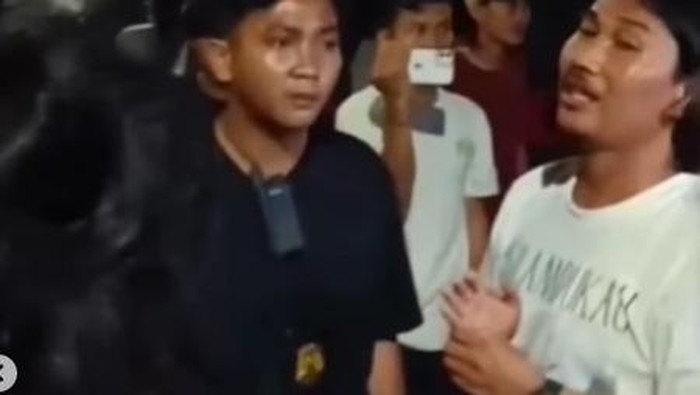 Pria beratribut polisi (baju hitam) cekcok dengan warga di Makassar.