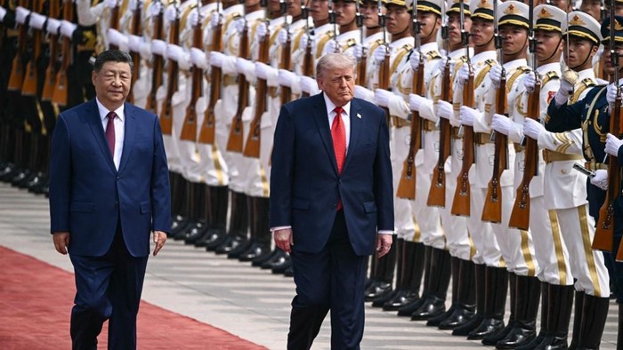 Xi Jinping dan Trump berjalan bersisian dalam seremoni penyambutan di Aula Besar Rakyat di Beijing pada Kamis (14/5) pagi (AFP/BRENDAN SMIALOWSKI)