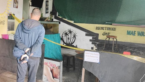Area ruang tunggu pelanggan tempat cuci motor dekat lokasi mayat terkubur di Desa Darmasaba, Badung, dipasang garis polisi, Jumat (15/5/2026). (Agus Eka/detikBali)