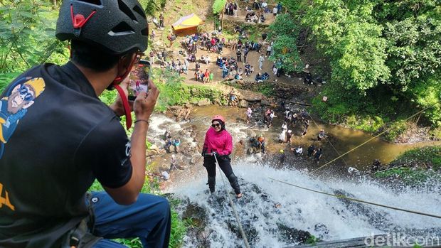 wisatawan menjajal waterfall rappeling dari ketinggian 28 meter di Curug Tilu Leuwi Opat Bandung Barat