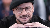 John Travolta Tampil Lagi dengan Topi Baret di Red Carpet, Ada Alasannya