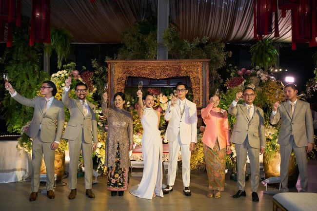 Saat putranya menikah, Ferry Salim dan sang istri, Merry, tampil serasi dalam balutan busana formal. Merry memilih kebaya kurung panjang dengan detail slit di bagian depan yang memberi sentuhan modern pada desain klasik. Potongan tersebut membuat penampilannya tampak anggun sekaligus tetap trendi. Foto: Dok. Instagram