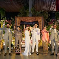 Saat putranya menikah, Ferry Salim dan sang istri, Merry, tampil serasi dalam balutan busana formal. Merry memilih kebaya kurung panjang dengan detail slit di bagian depan yang memberi sentuhan modern pada desain klasik. Potongan tersebut membuat penampilannya tampak anggun sekaligus tetap trendi. Foto: Dok. Instagram