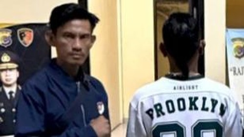 Seorang pria berinisial JZP (baju putih) saat diamankan di Mapolda NTT, Jumat (15/5/2026).