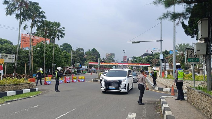Polisi menerapkan rekayasa sistem satu arah atau one way pada libur long weekend siang ini di Jalan Raya Puncak, Bogor, Jawa Barat. One way diterapkan dari arah Puncak menuju Jakarta, Sabtu (16/5/2026).