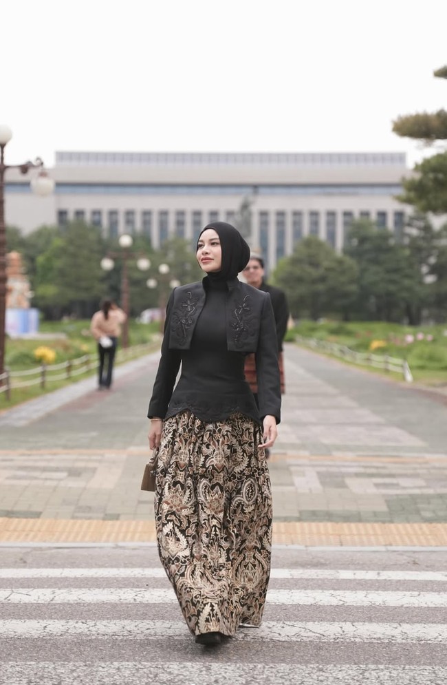 Di look berbeda, Aurel memilih padukan kain batik sebagai bawahan dengan atasan hitam yang modern dan sleek. Penampilannya semakin lengkap dengan hijab yang membungkus kepalanya. Foto: Instagram/@aurelie.hermansyah