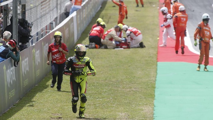 BARCELONA, SPAIN - MAY 17: Fabio Di Giannantonio of Italy riding the Pertamina Enduro VR46 Ducati (49) runs back to the paddock after crashing out as Alex Marquez is being treated in the background during the MotoGP of Catalonia at Circuit de Barcelo