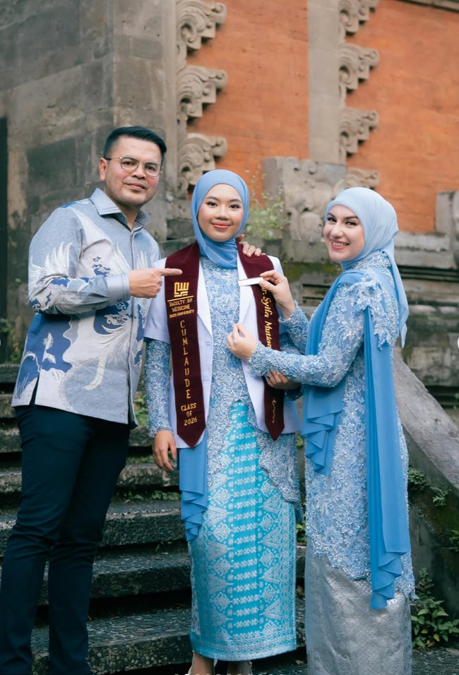 Irish mengenakan kebaya panjang berwarna biru muda dengan detail payet dan bordir penuh di bagian atas hingga lengan. Potongan kebayanya fitted sehingga memberi siluet anggun dan rapi. Bagian bawahnya dipadukan dengan kain atau rok satin warna silver. Foto: Instagram/@_irishbella_