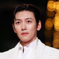 Lawan main Jun Ji Hyun, Ji Chang Wook, tampil elegan dalam setelan jas dari koleksi Tom Ford. Bintang drakor ‘The Manipulated’ ini memadukan jas bertekstur dengan kemeja putih, celana hitam dan syal tipis yang disampirkan di leher. Foto: AFP/SAMEER AL-DOUMY