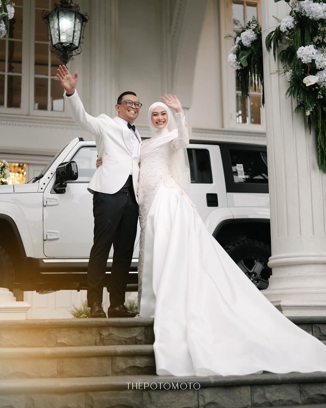 Penataan hijab oleh @suciaurelias sengaja dibuat minimalis tanpa banyak lilitan agar keindahan payet pada gaun dan veil-nya tetap menjadi pusat perhatian. Bagian veil pada robe terdapat inisial Dhani dan Nada yang cantik dari @ziabrides. Foto: Dok. Instagram @thepotomoto.