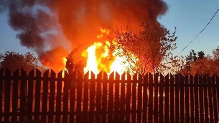 Sebuah rumah terbakar di desa Subbotino, Rusia, setelah dihantam oleh drone Ukraina pada hari Minggu. (Reuters: Handout/Andrei Vorobyov)