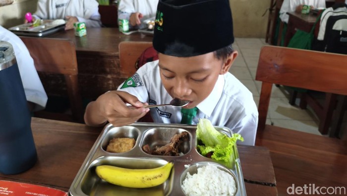 Marfen sedang makan MBG di MI Darussalam Sugihwaras Kecamatan Candi Sidoarjo