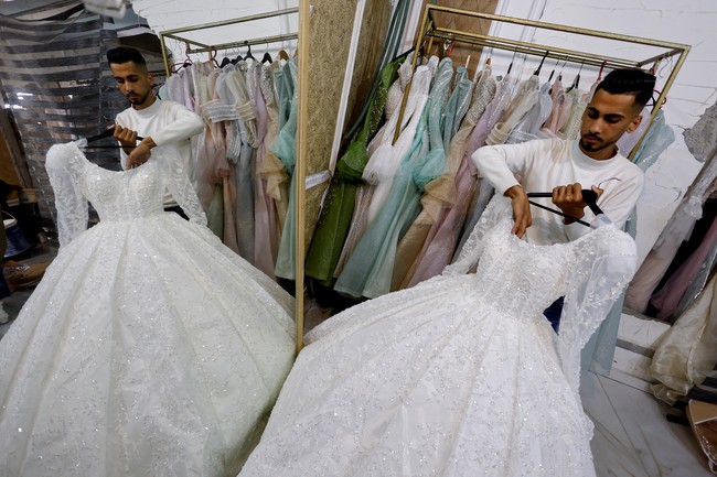 Namun sebuah harapan datang dari sebuah bengkel jahit kecil di Gaza selatan. Penjahit bernama Nisreen Al-Rantisi menyulap kembali gaun pengantin lama yang usang.  Foto: REUTERS/Mahmoud Issa