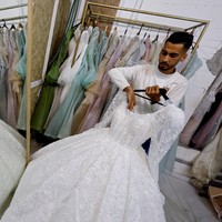 Namun sebuah harapan datang dari sebuah bengkel jahit kecil di Gaza selatan. Penjahit bernama Nisreen Al-Rantisi menyulap kembali gaun pengantin lama yang usang.  Foto: REUTERS/Mahmoud Issa