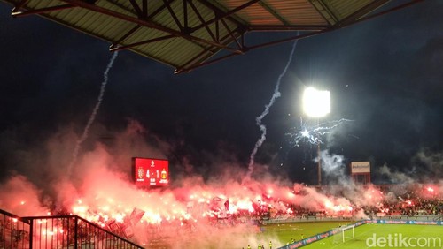 Seorang kameramen terkena lemparan kembang api saat Bali United vs Bhayangkara Presisi Lampung FC di Stadion Kapten I Wayan Dipta, Minggu (17/5).