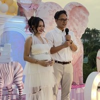 Nanda tampil kompak dengan suami mengenakan busana berwarna putih. Ia memilih dress ruffle halter neck. Dress tersebut memiliki bagian bawah yang menerawang. Foto: Instagram/@nandaarsynt