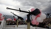 Dekorasi balon tampak menghiasi sejumlah perlengkapan militer di lokasi acara. Salah satunya terlihat terpasang pada senapan mesin yang dipamerkan saat kegiatan berlangsung. Majid Asgaripour/WANA via REUTERS