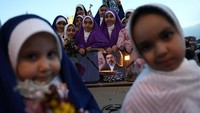 Anak-anak juga terlihat berada di atas kendaraan militer selama prosesi berlangsung. Mereka ikut menyaksikan rangkaian acara bersama para peserta lainnya. Majid Asgaripour/WANA via REUTERS