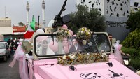Beberapa pasangan kembali terlihat menaiki kendaraan militer saat memasuki area kegiatan. Prosesi tersebut menarik perhatian warga yang hadir di lokasi. Majid Asgaripour/WANA via REUTERS