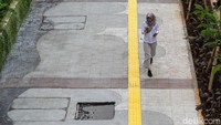 Pejalan kaki melintas di trotoar Jalan Rasuna Said, Kuningan, Jakarta, Selasa (19/5/2026).