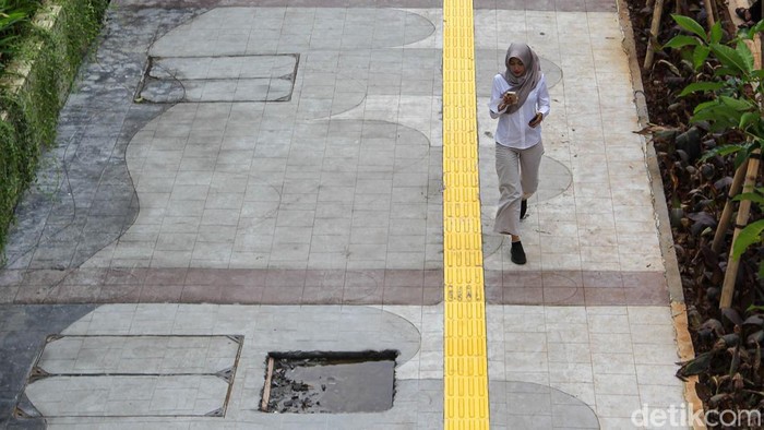 Pejalan kaki melintas di trotoar Jalan Rasuna Said, Kuningan, Jakarta, Selasa (19/5/2026). Revitalisasi sisi timur kawasan itu kini capai 60 persen.