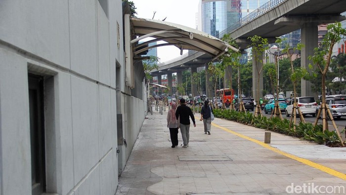 Pejalan kaki melintas di trotoar Jalan Rasuna Said, Kuningan, Jakarta, Selasa (19/5/2026). Revitalisasi sisi timur kawasan itu kini capai 60 persen.