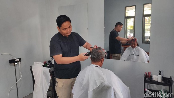 Salah satu peserta pelatihan sedang memangkas rambut pelanggan di Barbershop Dinas Sosial Ciamis