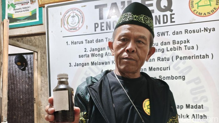 Sesepuh Penca Cimande Didih Supriadi (61) atau akrab disapa Aki Didih memperlihatkan minyak Cimande yang legendaris