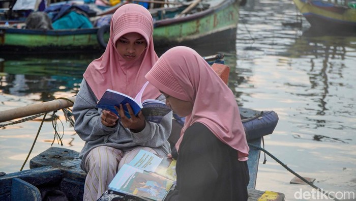 Sejumlah anak membaca buku di atas perahu saat mengikuti kegiatan Taman Anak Pesisir di kawasan Kalibaru, Cilincing, Jakarta Utara, Senin (18/5/2026). Ruang belajar alternatif yang berdiri sejak 2019 tersebut menjadi wadah edukasi bagi anak-anak pesisir untuk meningkatkan minat baca dan semangat belajar.