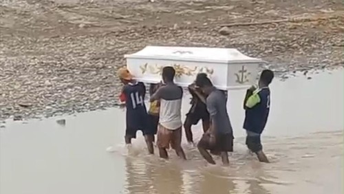 Warga menggotong peti jenazah secara estafet saat menyeberangi Sungai Kapsali, Desa Manubelon, Kecamatan Amfoang Barat Daya, Kabupaten Kupang, NTT. (Tangkapan layar video viral)